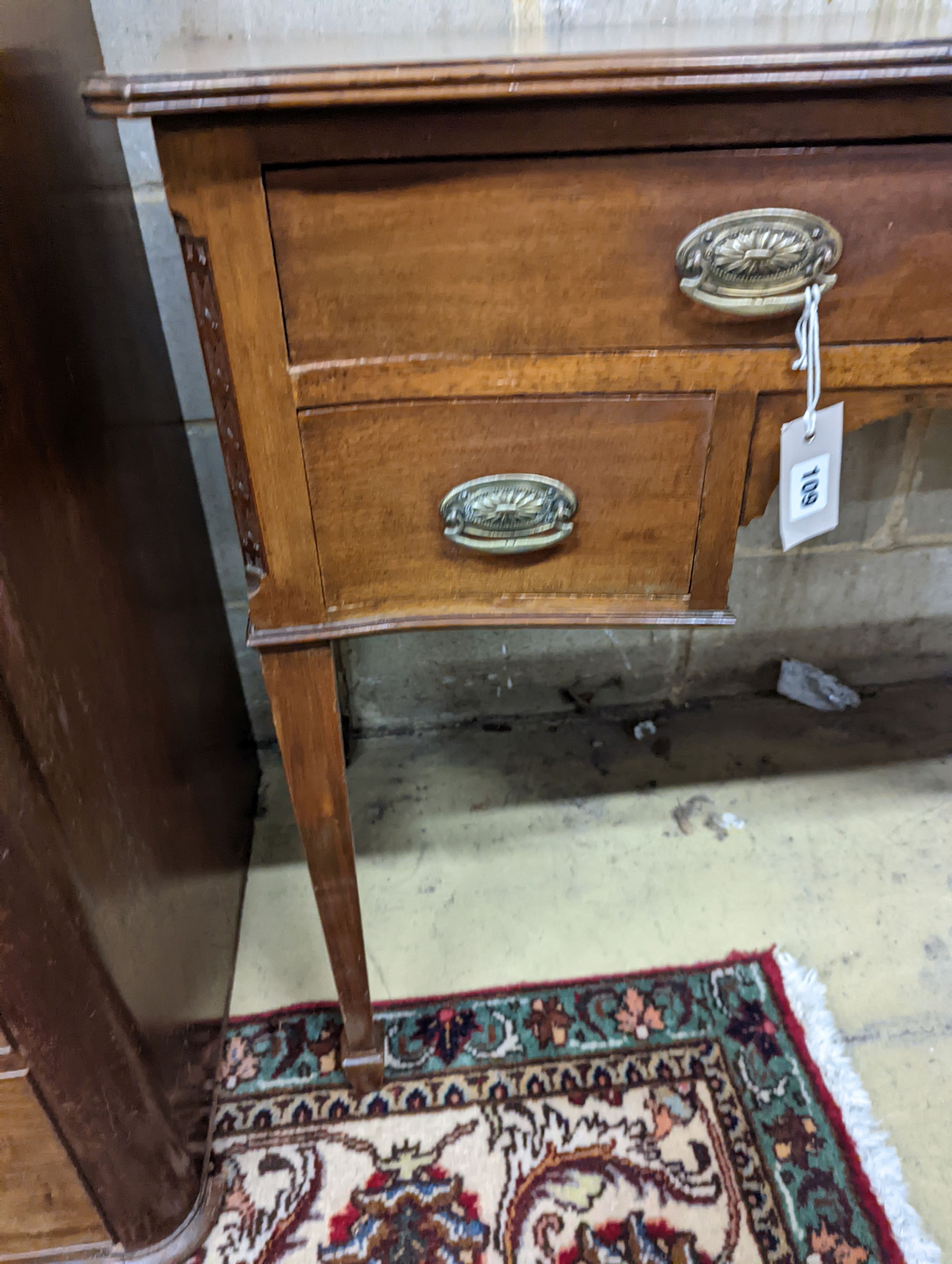 An Edwardian mahogany serpentine kneehole dressing table. W-106cm, D-53cm, H-79cm.
